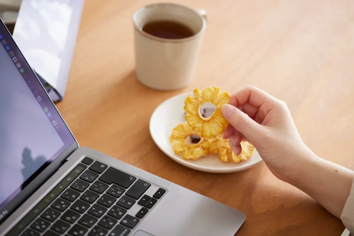 仕事をしながらスナックミーの置き菓子ドライフルーツをつまむ様子