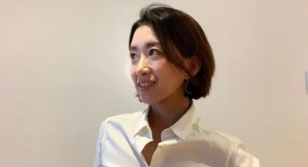 斜め上を見るワイシャツを着たショートカットの女性