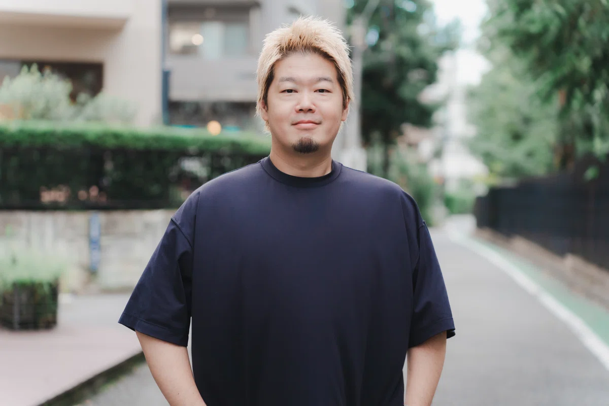 写真。胸を張り立つYagiさん。