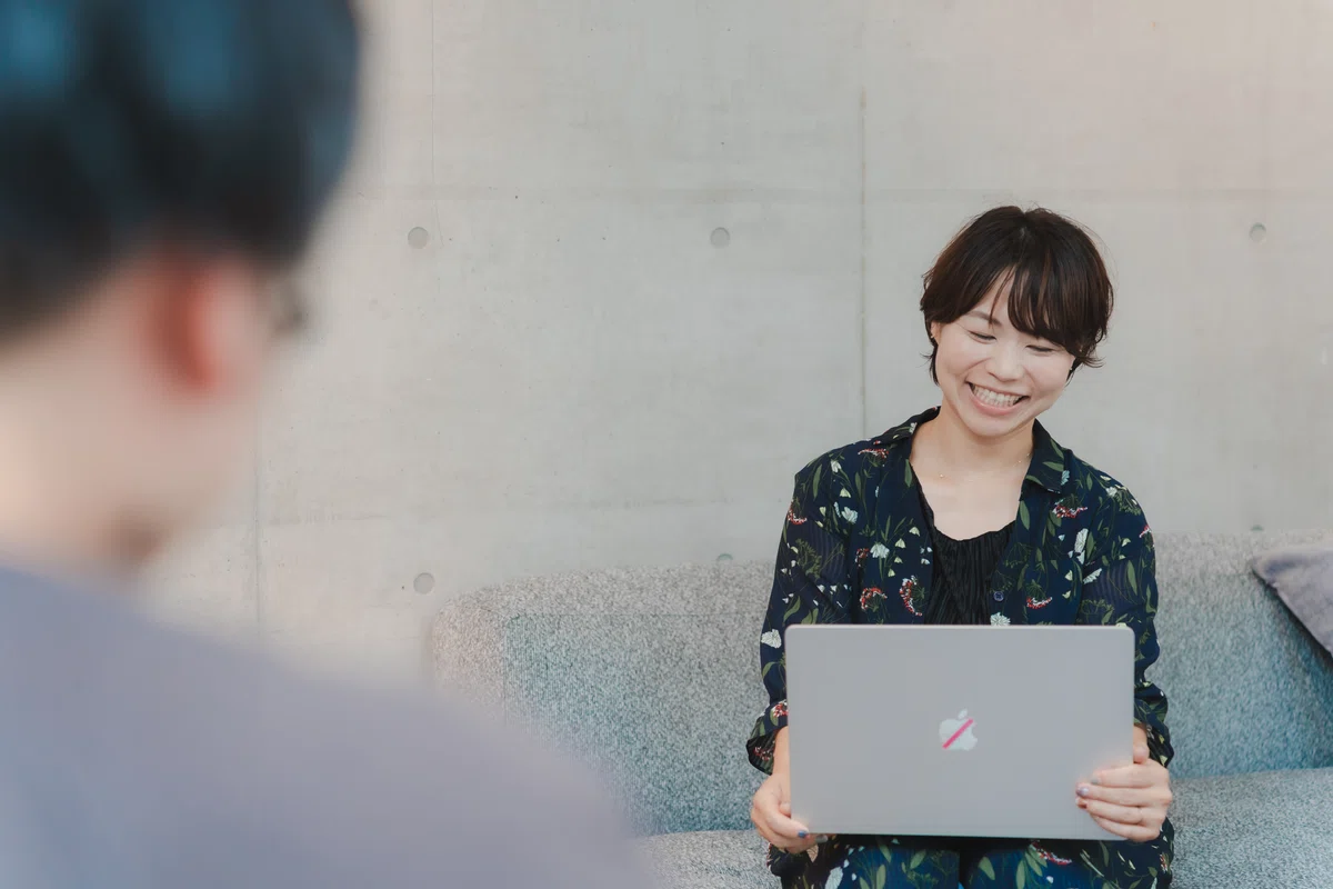 写真。手元のPCに目線を落とし、質問者と会話するCaoryさん。