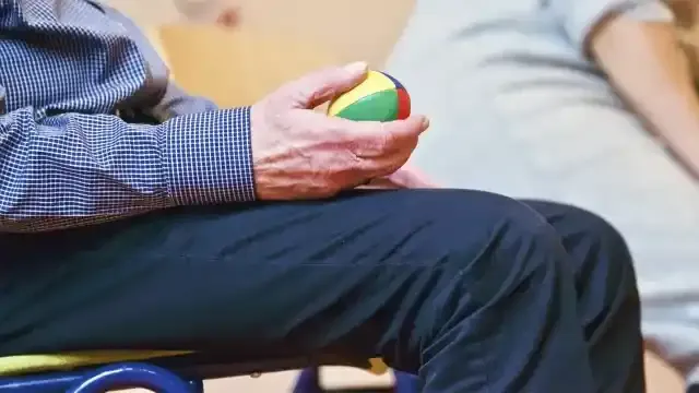 ボールを手にもって椅子に座る人