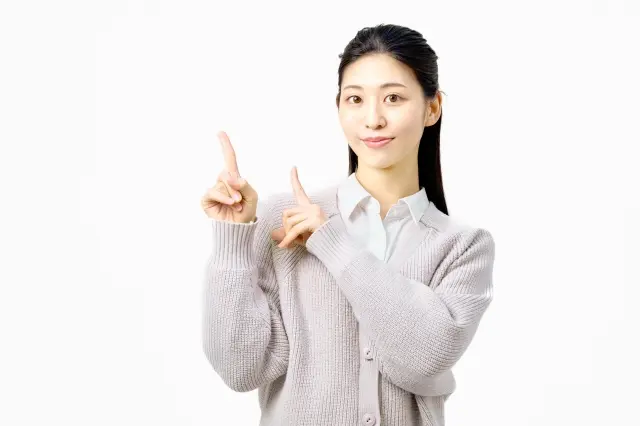 指差しポーズで案内する女性