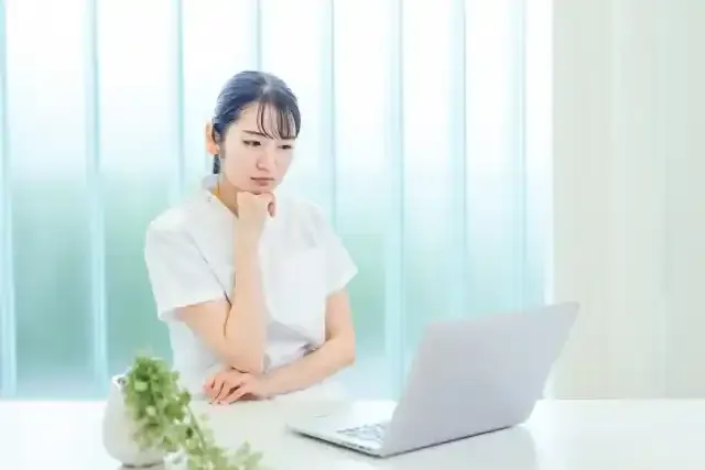 パソコンを使う白衣姿の女性（困る）