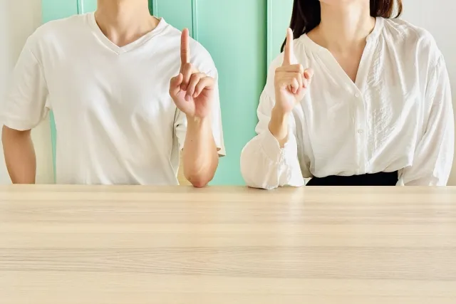指でポイントを示す男女