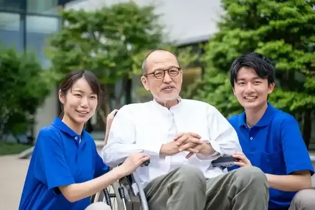 車いすのシニア男性と介護施設スタッフ