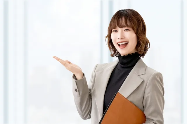 手で案内をする女性・ビジネスウーマン