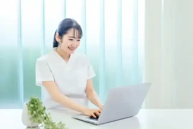 パソコンを使う白衣姿の女性