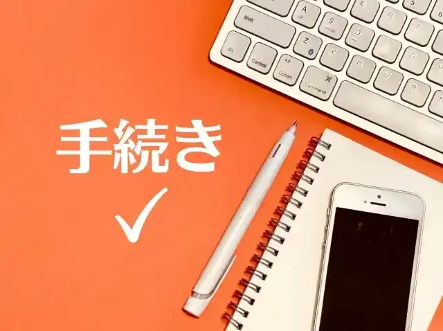 手続きと書かれた文字とキーボードとスマホとペン