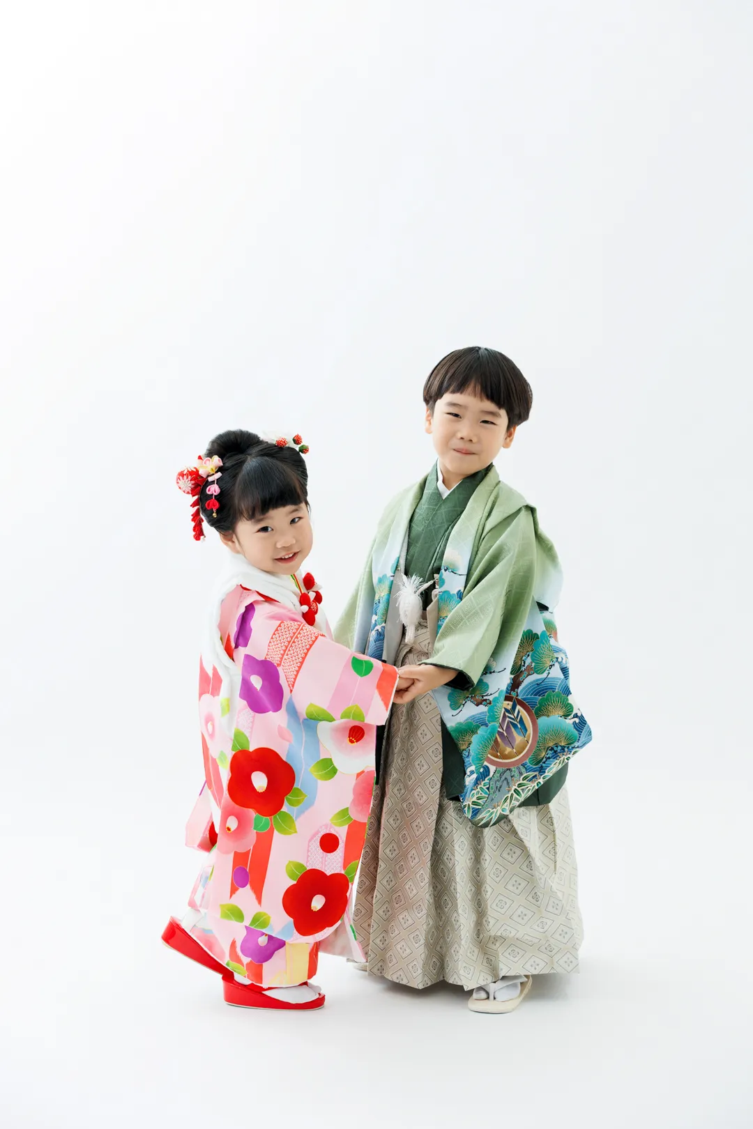 ピンクの花柄着物の妹と緑の着物の兄が並んで立つ兄妹の七五三記念写真（小松市）｜ヤマダフォト