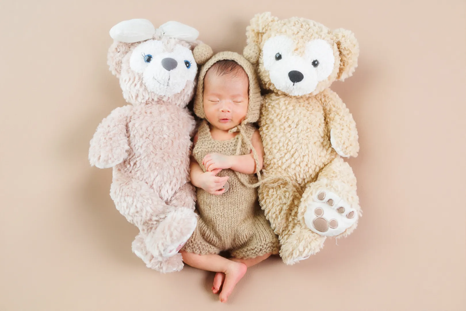 大きなくまのぬいぐるみに挟まれて眠る新生児の女の子のニューボーンフォト(能美市)|ヤマダフォト