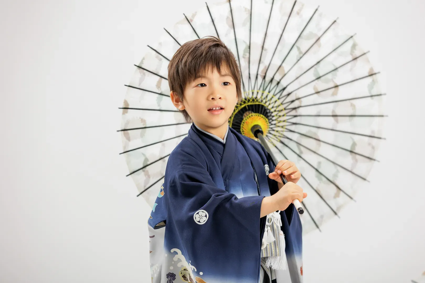 紺の着物を着て大きな和傘を持つ5歳男の子の七五三記念写真(野々市市)|ヤマダフォト