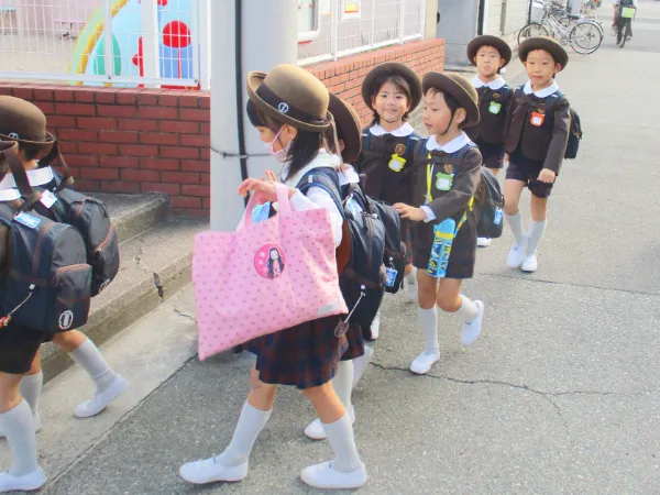 園児が給食のご飯を食べて口の端からこぼしている写真