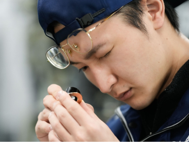 加工部品を手に取り品質を確認するパール技研の技術者