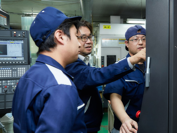 現場で技術を共有し品質確認を行う社員たち