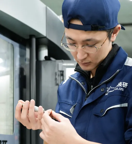 阿部さんが加工した部品を手に取り確認している様子