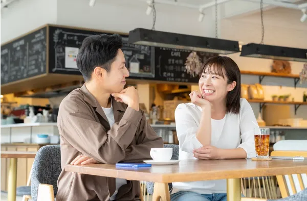カフェで男性と女性が微笑み合う写真