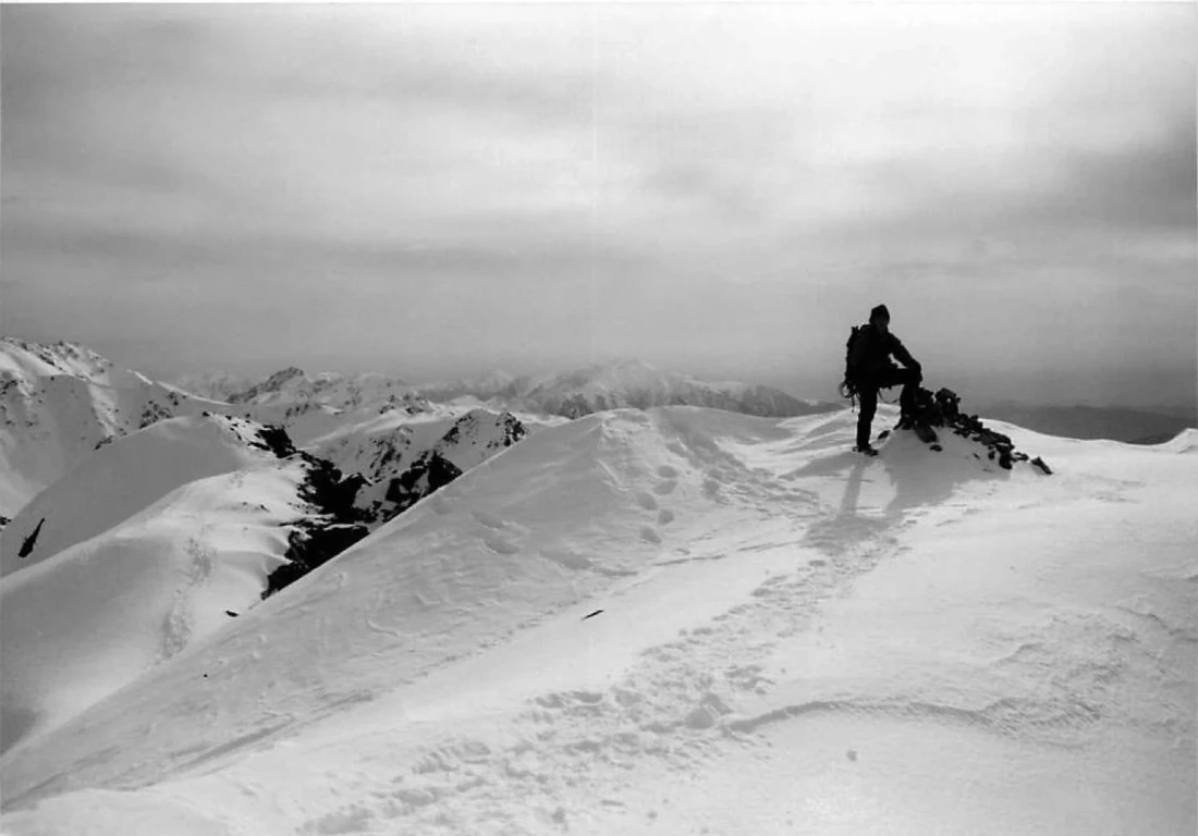 白黒の雪山稜線を歩くカウンセラーの過去写真