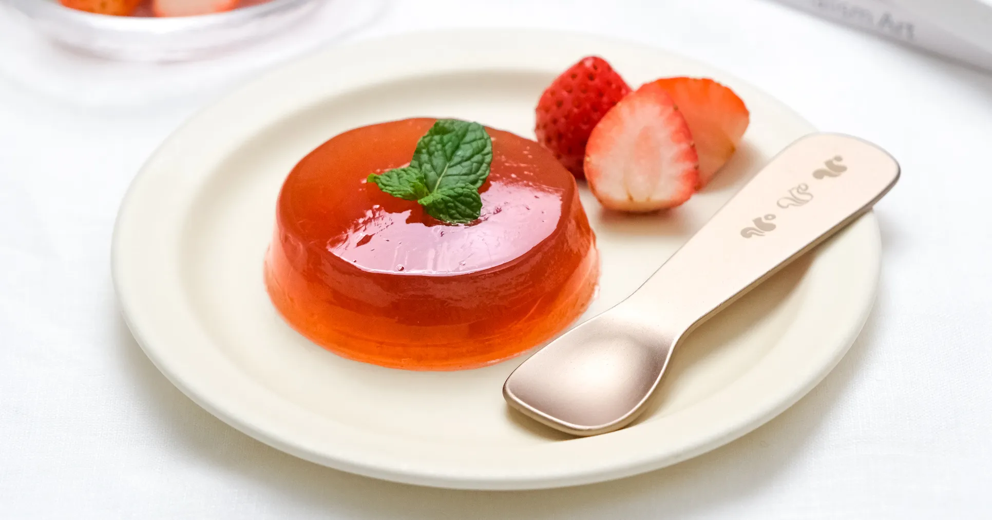 白いお皿に乗った苺といちごゼリーとスプーン