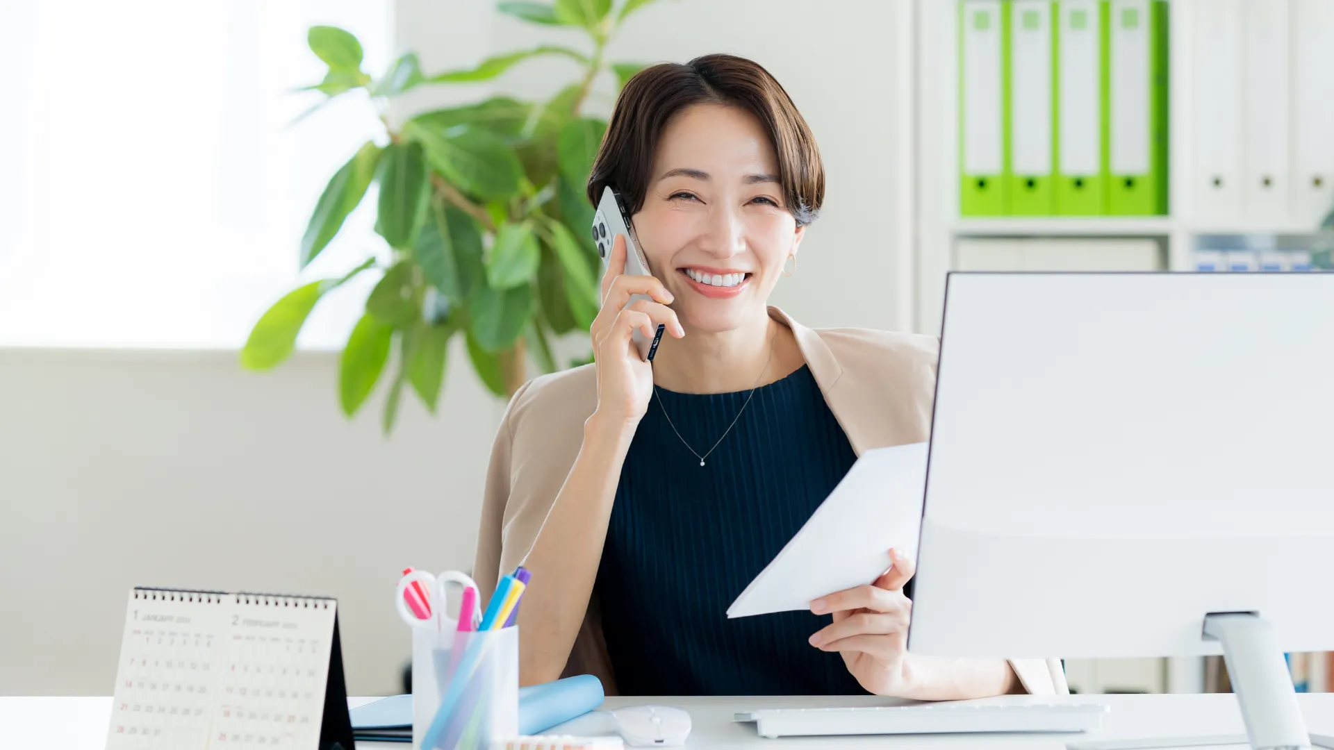 笑顔で腕組みをする二人のビジネスパーソン。DX-起案が役員から承認されたイメージ。