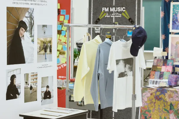 展示の様子_生徒の飾り付けしたパネルと作った洋服が飾られている