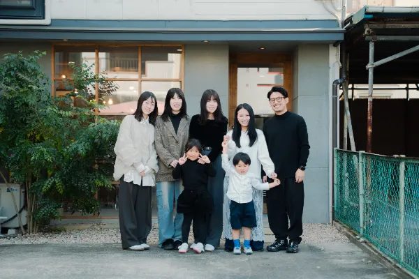 事務所の前で撮影した、和田力と家族と、スタッフの集合写真