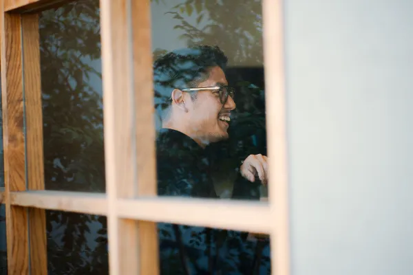 窓越しに映る、WOSH design 代表 和田 力の横顔