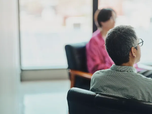 ALTはじまり: 背中越しに松本さんを写し、奥には田渕さんの姿が見える。対話の一場面。ALTおわり