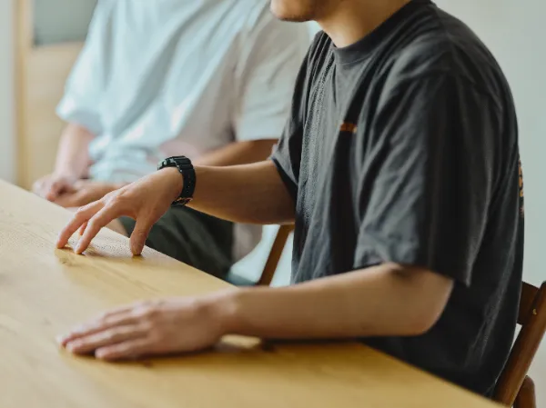 ALTはじまり: テーブルに手を置き、熱心に話をしている大塚さんの手元を捉えた写真。ALTおわり