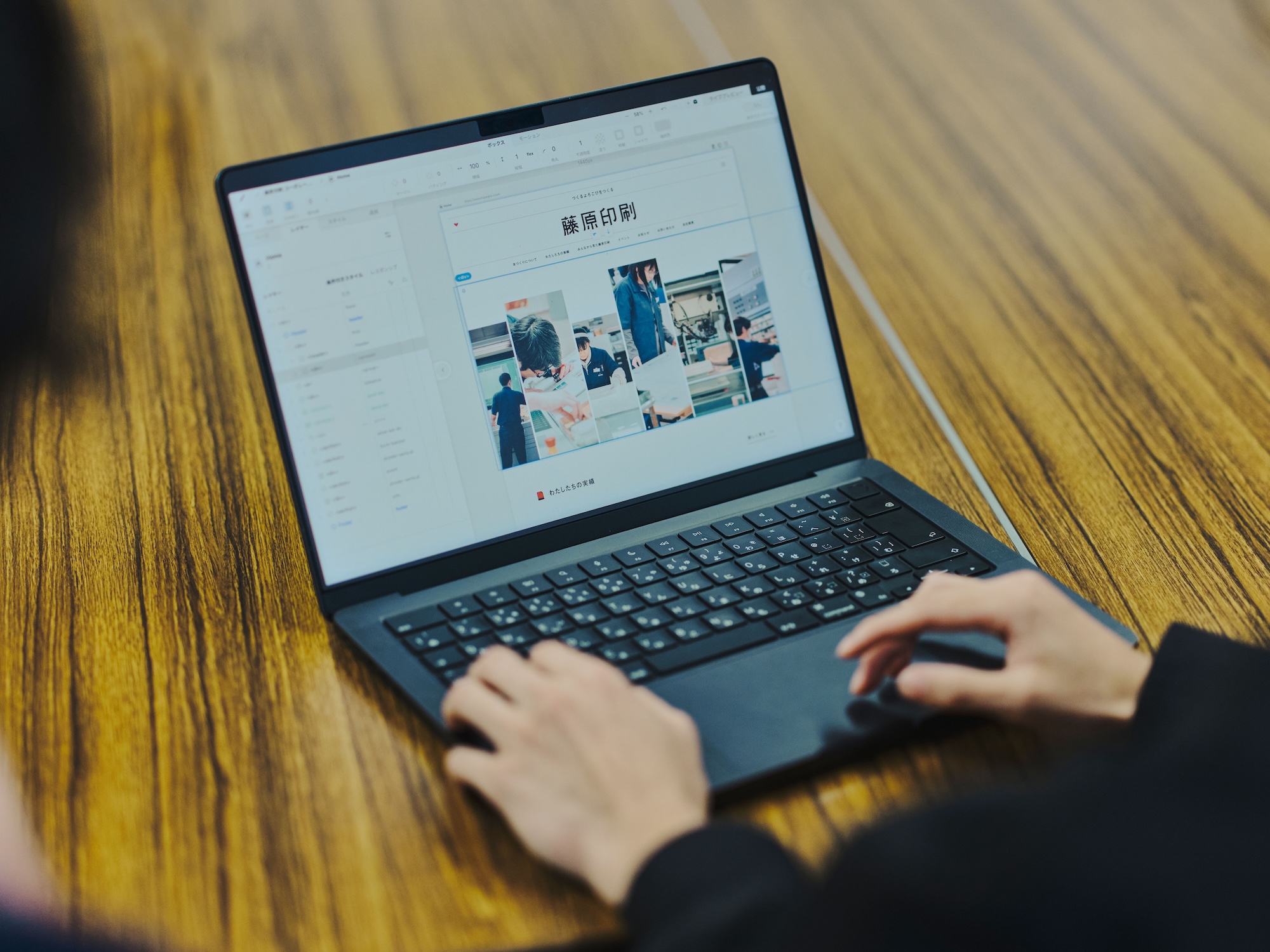 写真:会議室でパソコンを操作するnovactメンバーの手元。藤原印刷の新サイトのデザイン画面が表示されている。