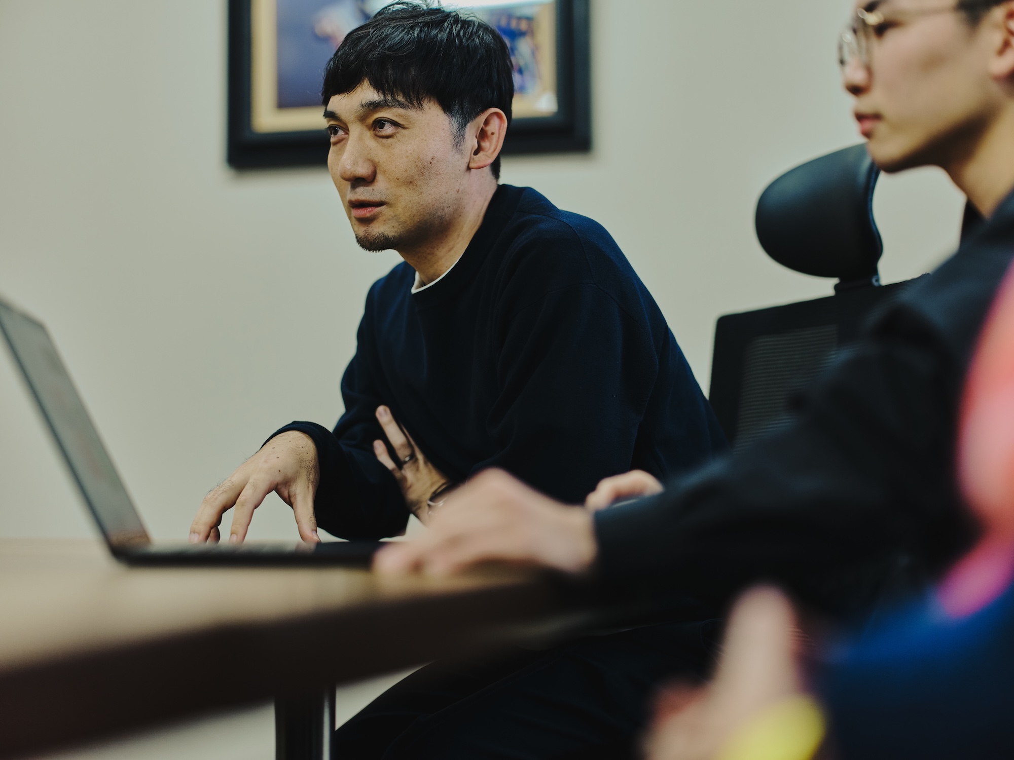 写真:藤原隆充さんが話している様子。手前には尾木さんの横顔とノートパソコンがある。