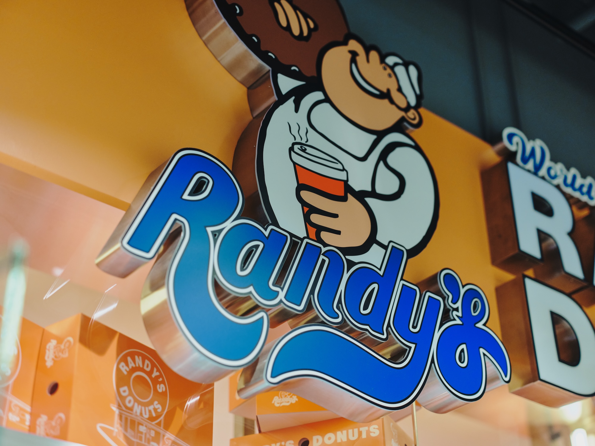 ALTはじまり: 「RANDY'S DONUTS」の店舗に設置された、ドーナツを持ったキャラクターの立体的な看板。ALTおわり