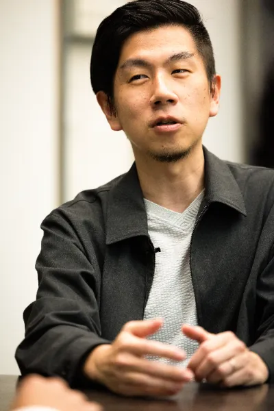 ALTはじまり：ブラックのジャケット、グレーのカットソーを着るアイティプラスの溝口さんが話している写真。ALTおわり