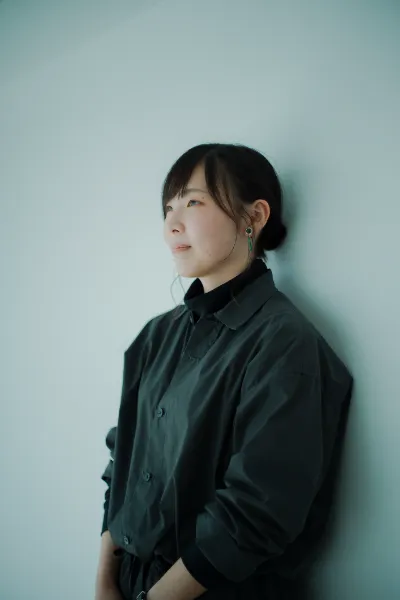  ALTはじまり： 白い壁にもたれかかり、遠くを見つめている大橋さん。ALTおわり