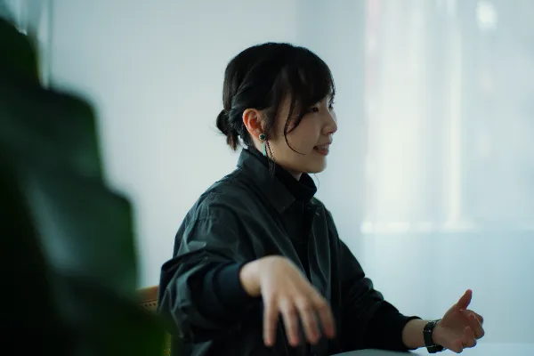  ALTはじまり：テーブルの向こうで話している、大橋さんの様子。 ALTおわり