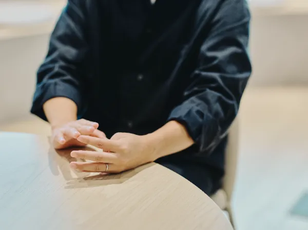 ALTはじまり:木目のテーブルに置かれた兼原さんの手元。ALTおわり