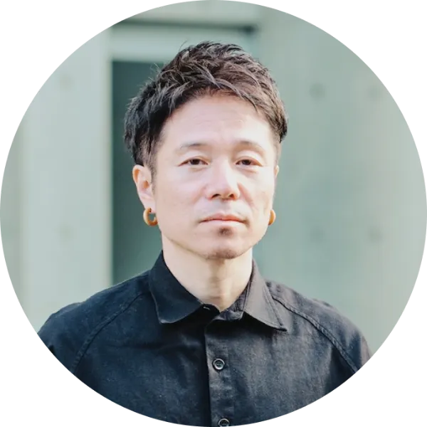 写真：RYDENのオフィスを背景に、正面を向いて写る井上さんのプロフィールカット。