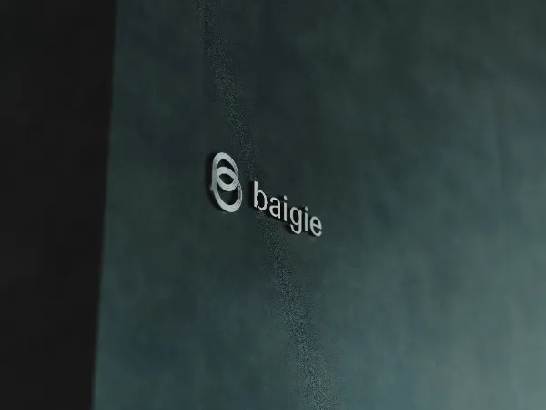 ALTはじまり: ベイジのオフィスにある、黒い背景の壁に会社のロゴ「baigie」が銀色の立体文字で刻印されている。ALTおわり