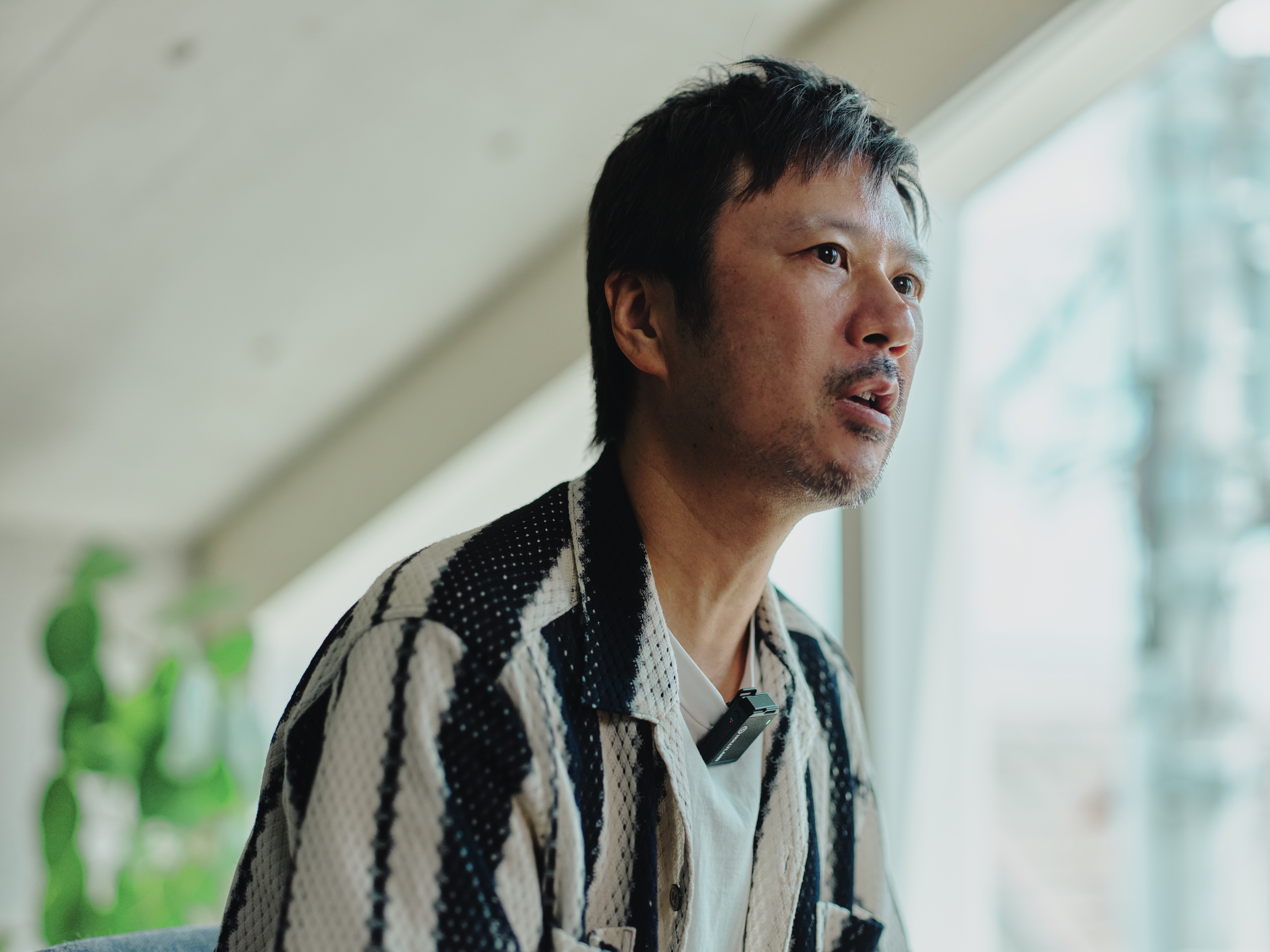 ALTはじまり: 窓からの光が差し込むベイジのオフィスで、真剣な表情で話しているベイジ代表の枌谷力さんのアップ。ALTおわり