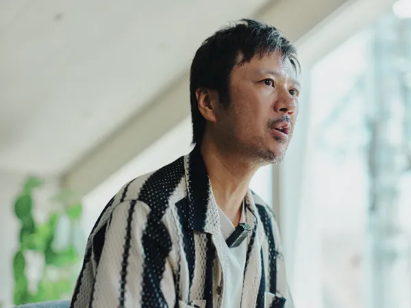 ALTはじまり: 窓からの光が差し込むベイジのオフィスで、真剣な表情で話しているベイジ代表の枌谷力さんのアップ。ALTおわり