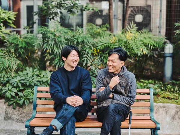 ALTはじまり:公園のベンチで笑い合う石井さんと高橋さん。リラックスした表情が写されており、自然の中での穏やかな時間が伝わる。ALTおわり
