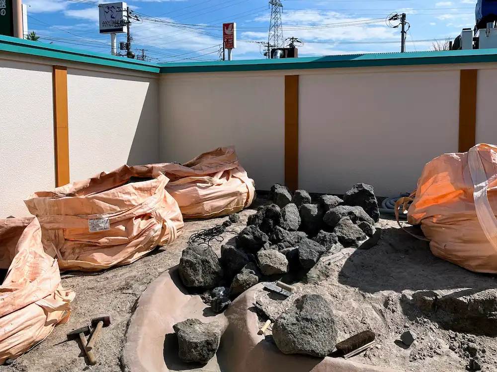 自然石を積み上げて作られた小川のような流れの造作。一面に広がる鮮やかな苔の中に、石組みと多様な樹木が配置され、山奥の渓流を切り取ったような趣のあるモダンな和風施工例。