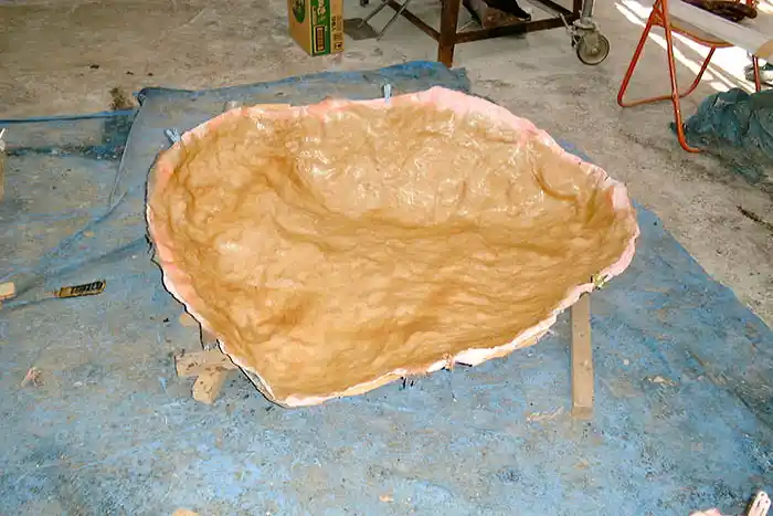 擬石の製作工程2。岩の表面の凹凸をかたどった、茶色の成形用型の内側。