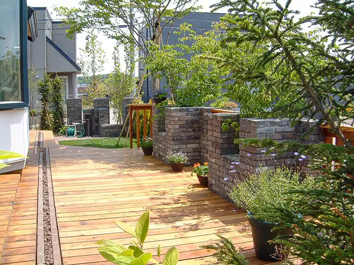 家から続く広いウッドデッキがあり、レンガをふんだんに使用した高級感ある庭