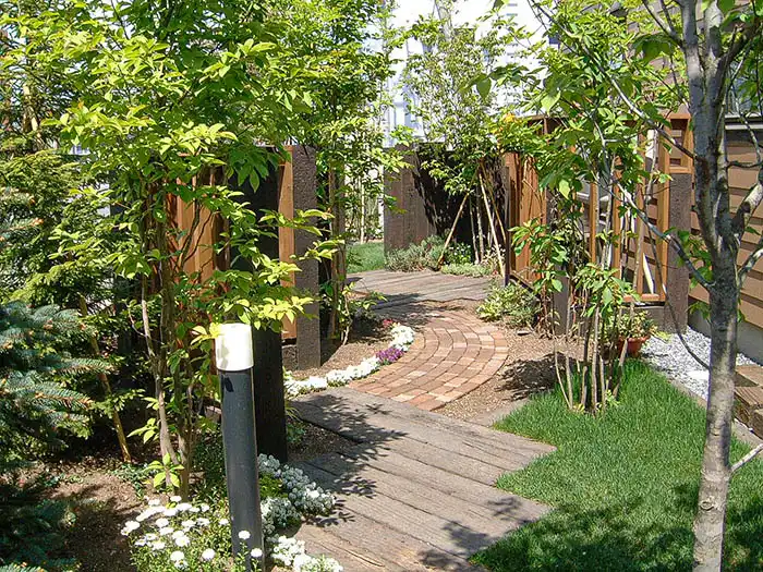 大小の木々や板塀に囲まれ、プライベート空間のあるナチュラルな庭