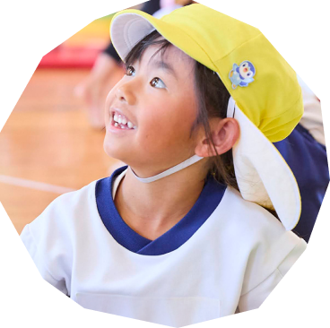 幼児がシロツメクサのを花の香りを嗅いでいる写真