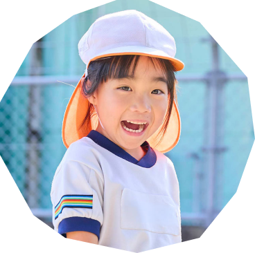 園庭で保育士と園児たちが泥遊びをしている写真