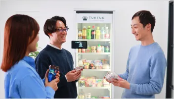 オフィスコンビニの前で談笑している男女の写真