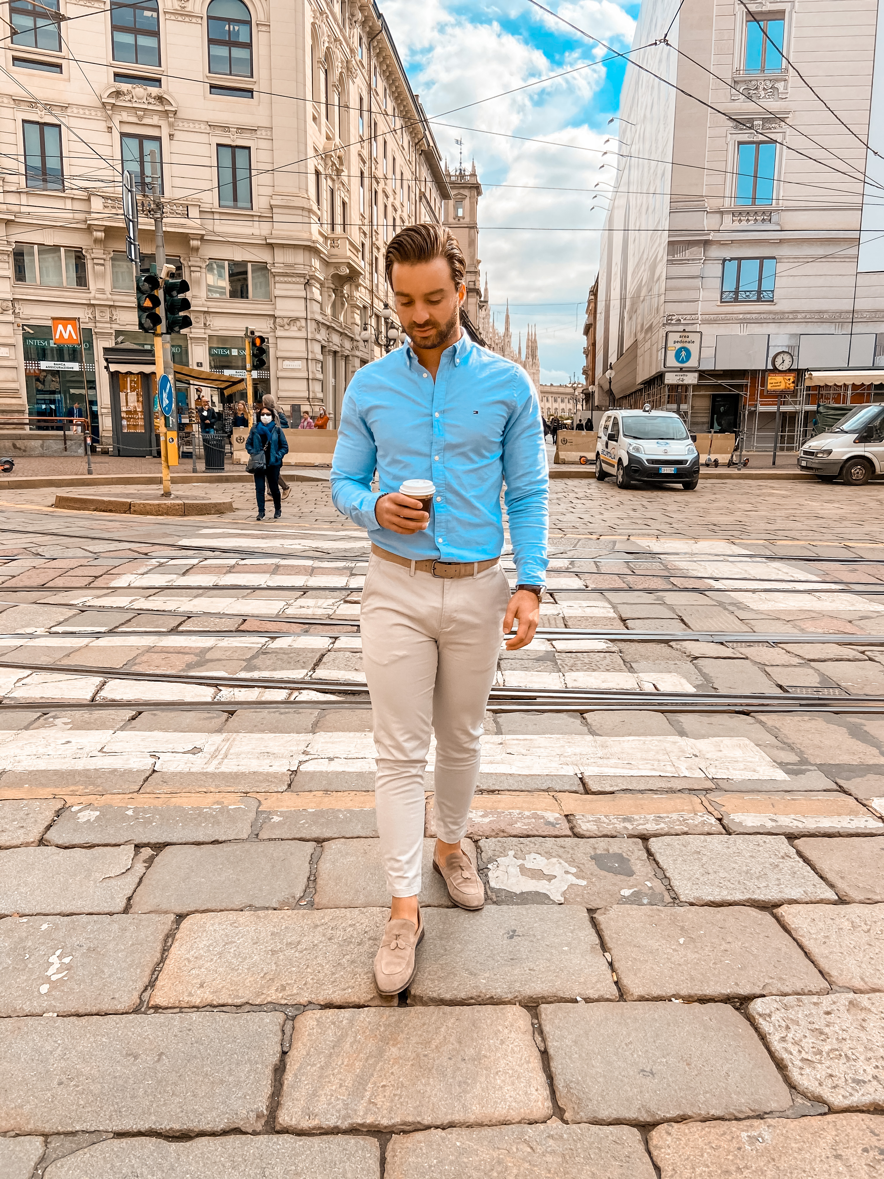 Looking elegant wearing a stripped blazer with a white shirt, beige  trousers and blue suede loafers