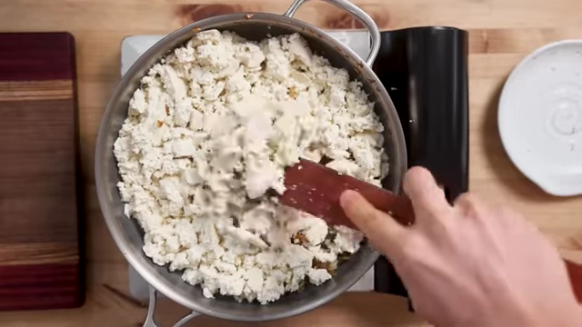 Crumbling firm tofu into a pan for Tofu Chorizo