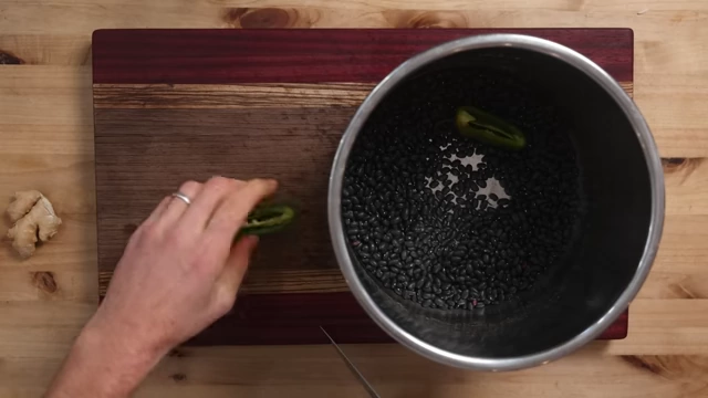 Dried black beans and aromatics in a pressure cooker